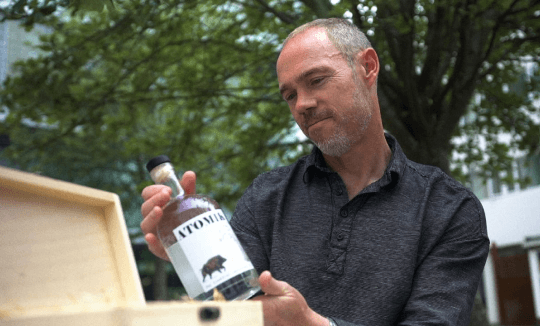 Jim the scientist appraising a bottle of Atomik spirit